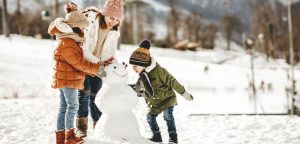 Woman making snowman with kids